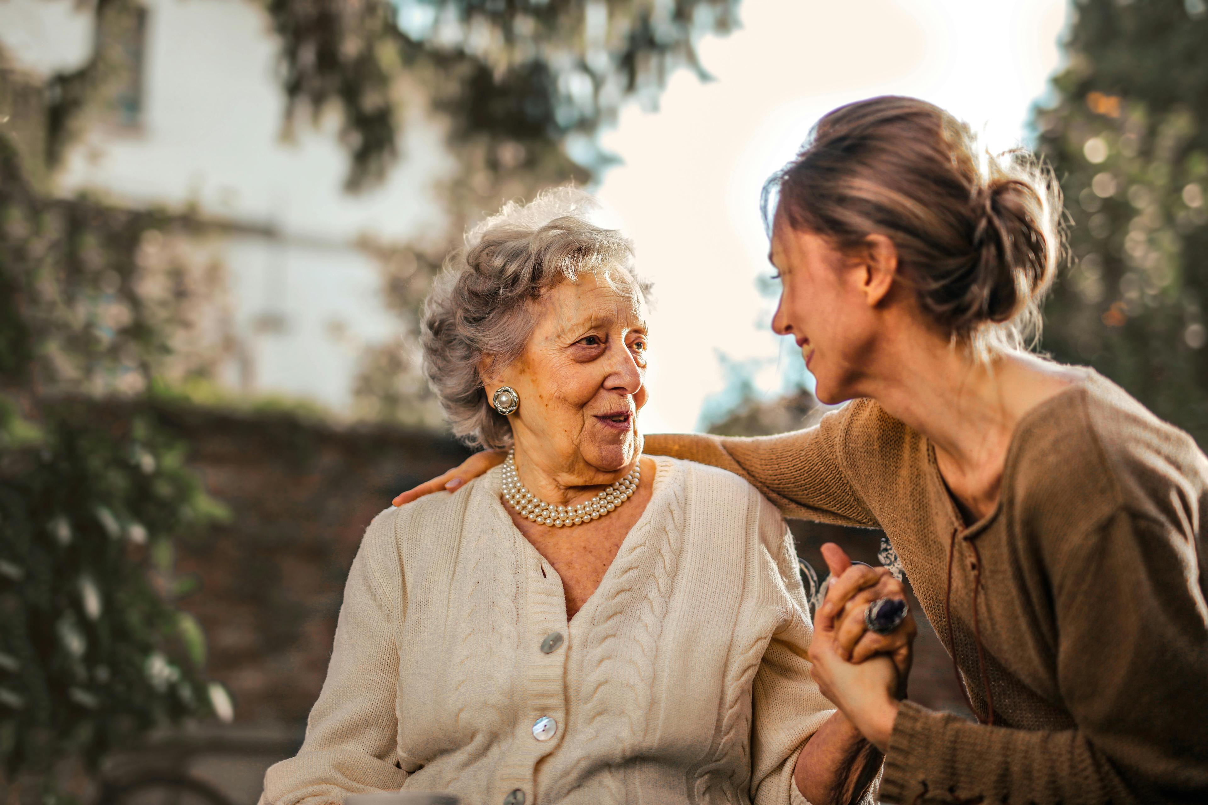 Elderly woman and younger woman sharing a caring moment